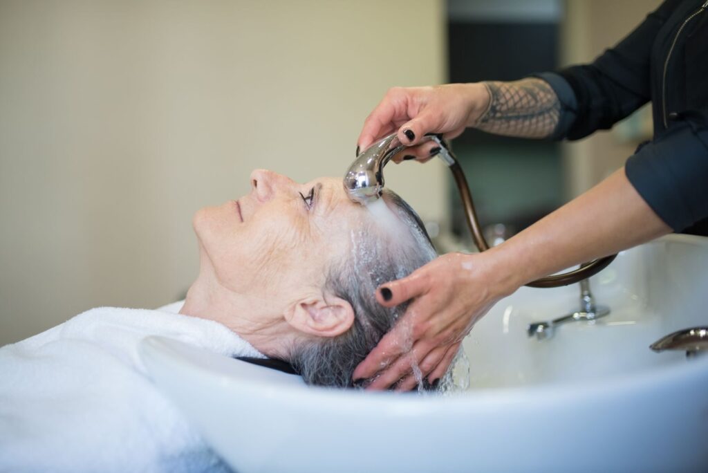 Khách được gội tóc tại bồn chuyên dụng trong salon