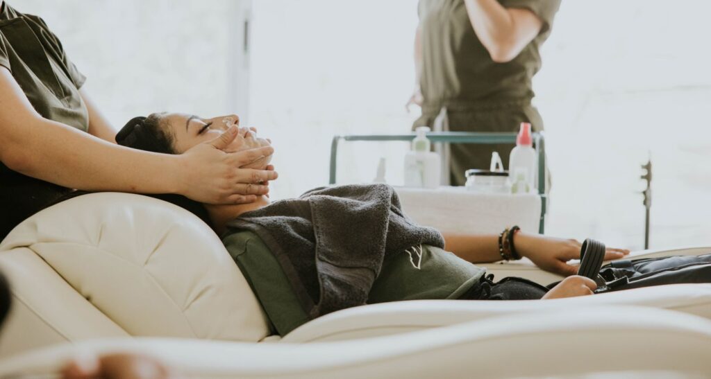 Khách nằm trên ghế trong lúc được massage mặt tại spa