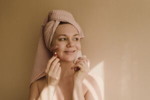Người phụ nữ dùng cây lăn và dụng cụ gua sha trong chăm sóc da
