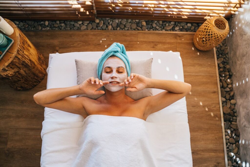 Người phụ nữ nằm thư giãn với mặt nạ chăm sóc da