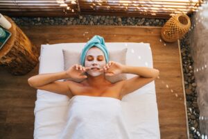 Người phụ nữ nằm thư giãn với mặt nạ chăm sóc da