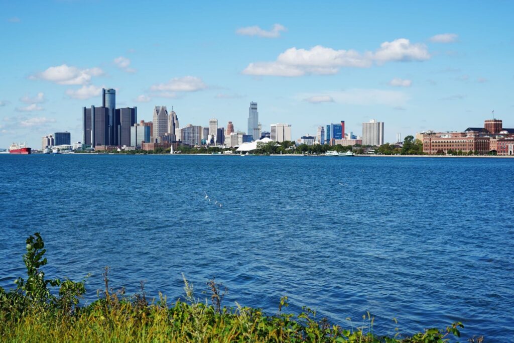 Đường chân trời Detroit nhìn qua mặt nước sông dưới bầu trời xanh