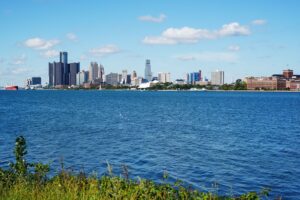 Đường chân trời Detroit nhìn qua mặt nước sông dưới bầu trời xanh