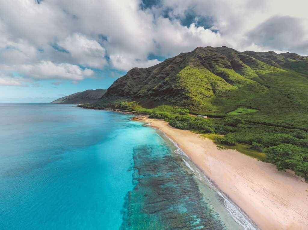 Bờ biển Hawaii nhìn từ trên cao với núi xanh và mặt nước trong