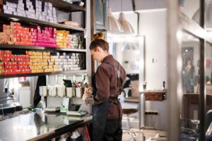 Thợ làm tóc sắp xếp sản phẩm trên kệ salon