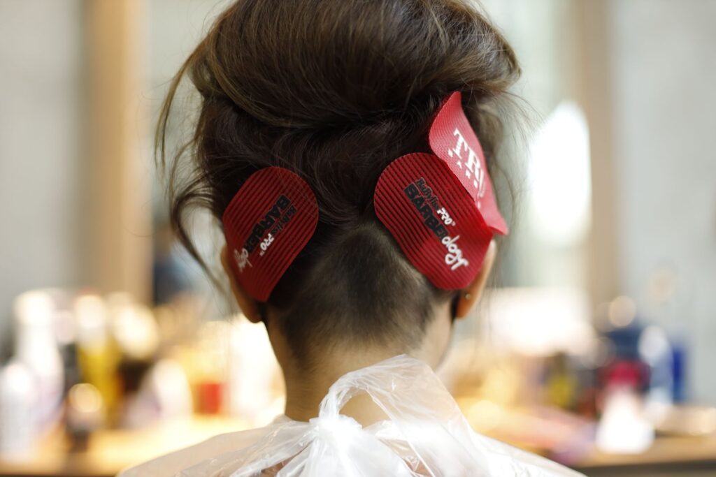 Phía sau mái tóc được chia phần và giữ bằng kẹp tại salon
