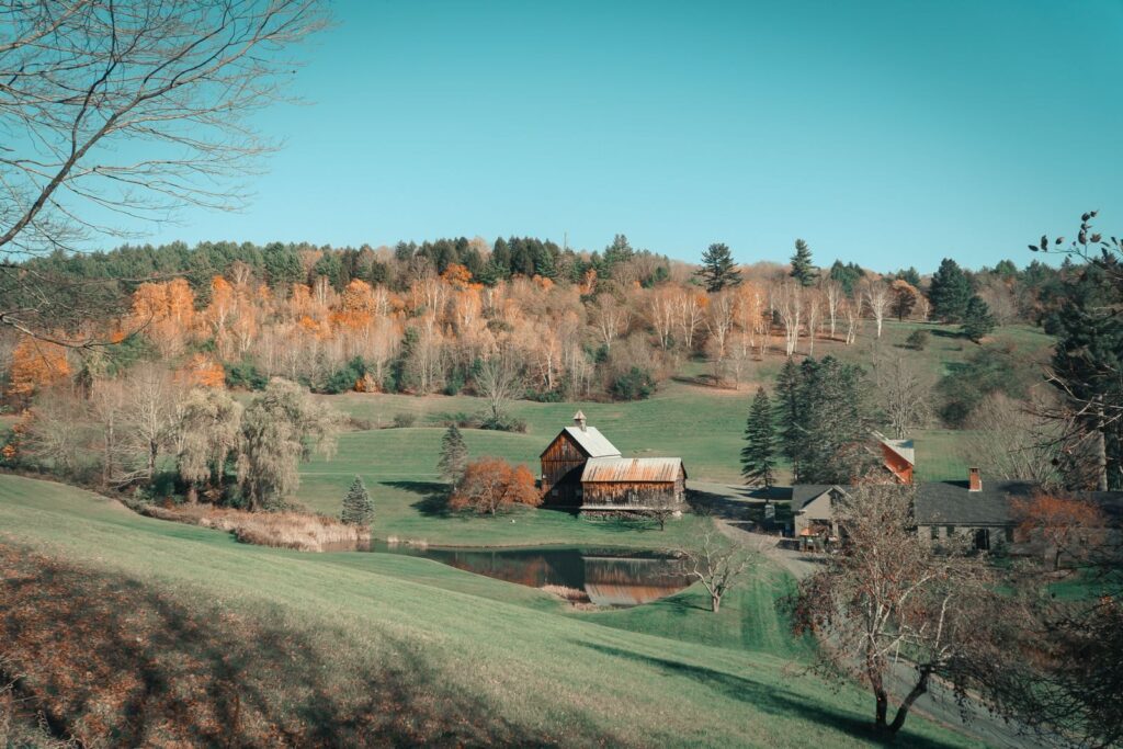 Nhà và kho nông trại giữa cây lá mùa thu ở Woodstock, Vermont