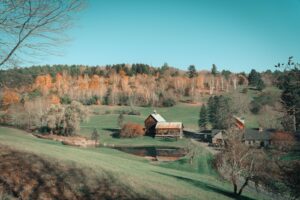 Nhà và kho nông trại giữa cây lá mùa thu ở Woodstock, Vermont